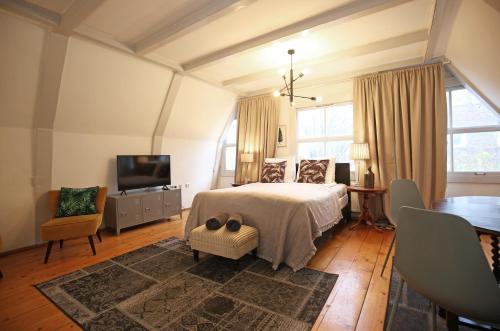 Un dormitorio con una cama y un televisor de pantalla plana. en Dok Apartments, en Ámsterdam