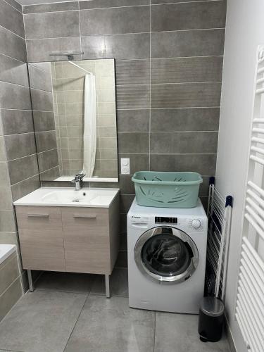 une salle de bain avec une machine à laver et un lavabo dans l'établissement Appartement neuf tout confort super emplacement, à Samoëns