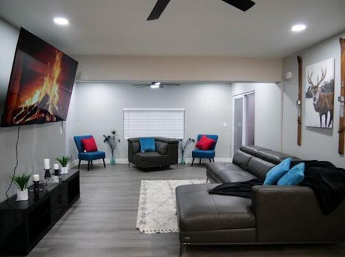 a living room with a leather couch and blue chairs at HOME away from HOME in Fort Myers