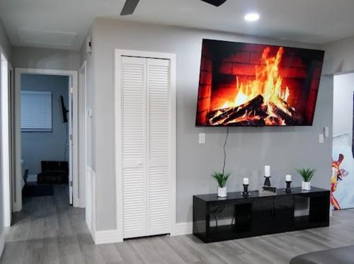 a living room with a fire painting on the wall at HOME away from HOME in Fort Myers