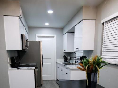 a kitchen with white cabinets and a silver refrigerator at HOME away from HOME in Fort Myers