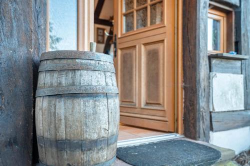 a wooden barrel sitting in front of a door at Maison Fleurie in Schwabwiller
