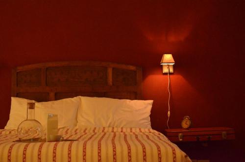 a bedroom with a bed with a red wall and a lamp at B&B La Buonora in Sinio