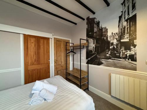 Dale View Cottages and Rooms - Whitby في Stainsacre: غرفة نوم بسرير وصورة على الحائط
