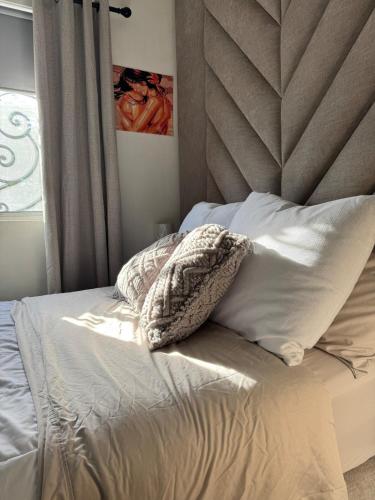 an unmade bed with a head board and pillows at Yes's house in Monterrey