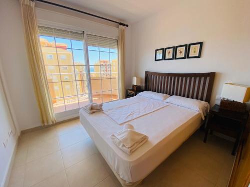 ein Schlafzimmer mit einem großen Bett und einem großen Fenster in der Unterkunft Canales de Veneciola by Alina365 in La Manga del Mar Menor