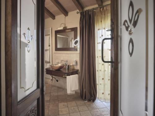 a bathroom with a sink and a mirror at Tenuta Montemagno Relais & Wines in Montemagno