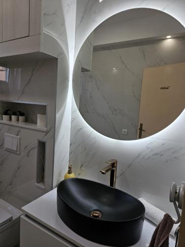 a bathroom with a black sink and a mirror at Apartments Nada in Sućuraj