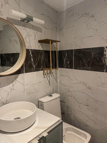 une salle de bain avec un lavabo, des toilettes et un miroir dans l'établissement Dépendance COLOMBES, à Saint-Germain-en-Laye