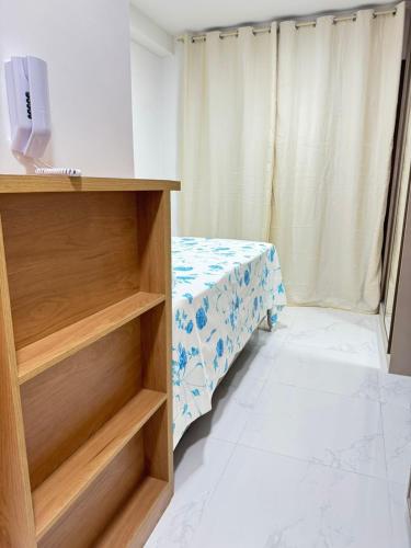 a room with a bed and a table with a curtain at Smart Convenções in Salvador
