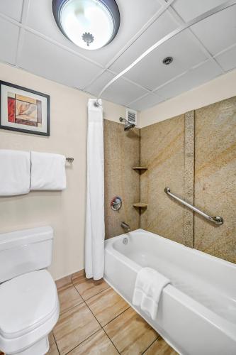 a bathroom with a white tub and a toilet at Radisson Hotel Schaumburg in Schaumburg