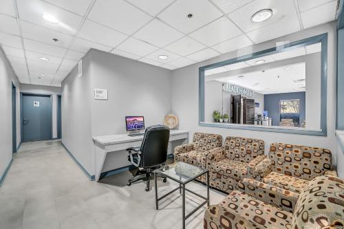 a waiting room with couches and a desk and a computer at Radisson Hotel Schaumburg in Schaumburg