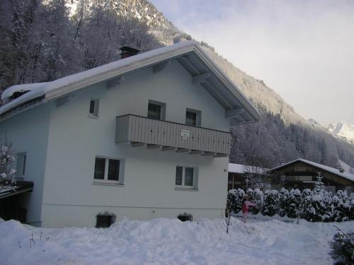 a white building with a balcony in the snow at Haus Can in Dalaas