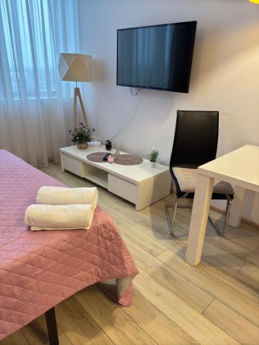 a room with a bed and a tv on the wall at Zlatarooms in Warsaw