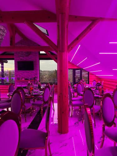 a room with purple lighting and tables and chairs at Domi Chalet in Şişeşti