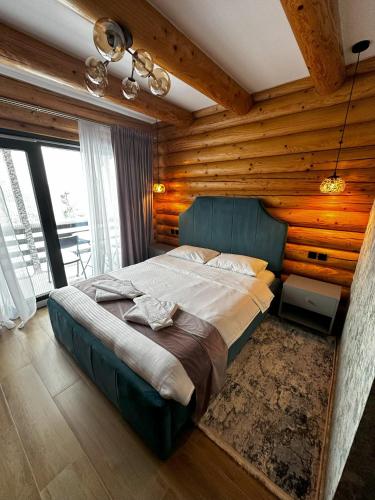 a bedroom with a large bed in a room with wooden walls at Domi Chalet in Şişeşti