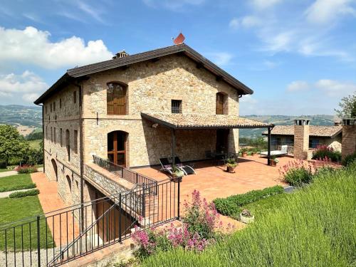a large stone building with a balcony in a yard at Agriturismo Podere Prasiano in Marano sul Panaro