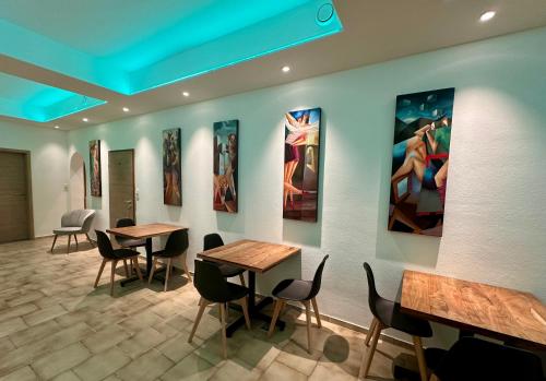 a restaurant with tables and chairs and paintings on the wall at BenDorma in Hannover