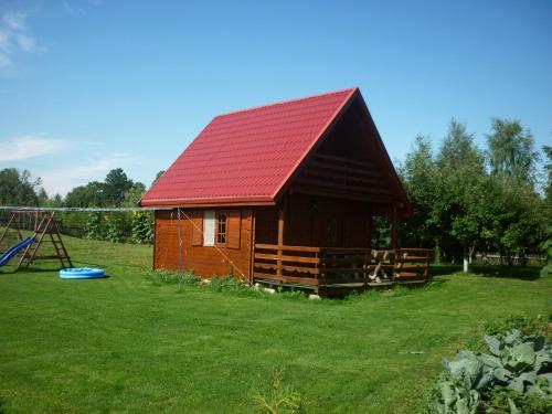 a small cabin with a red roof and a playground at Gospodarstwo Agroturystyczne & SPA z Alpakami in Ełk