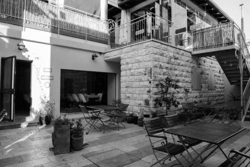 a patio with tables and chairs and a balcony at Villa Nazareth B&B in Nazareth