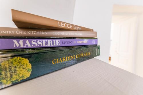 a stack of books sitting on top of a shelf at Casa Marta holiday home - "exclusive typical Salento house in historic center" in Tricase