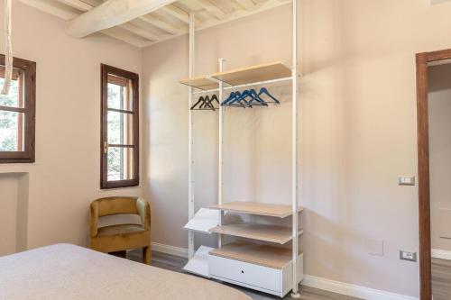a bedroom with a bed and a white shelf at Villa Il Poggetto - Tuscany living in Massa Marittima