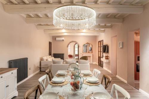 a dining room with a table and a chandelier at Villa Il Poggetto - Tuscany living in Massa Marittima