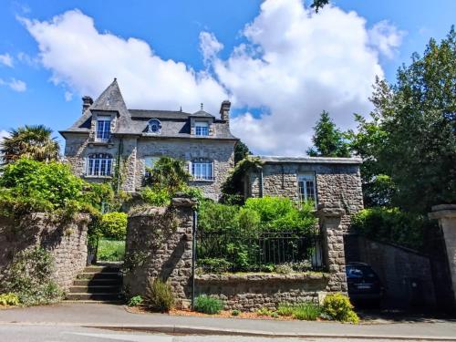une ancienne maison en pierre avec un portail dans l'établissement Chambres d'hôtes Bord de Rance, à Pleudihen-sur-Rance