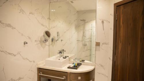 a white bathroom with a sink and a shower at فندق سدو بوتيك Hotel SDU BOUTIQUE in Jazan