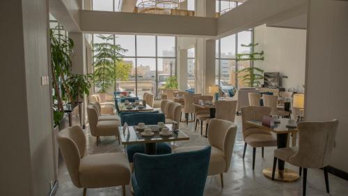 a restaurant with tables and chairs and windows at فندق سدو بوتيك Hotel SDU BOUTIQUE in Jazan