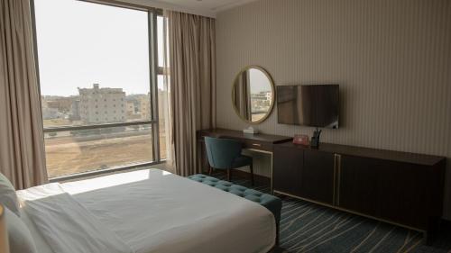 a hotel room with a bed and a large window at فندق سدو بوتيك Hotel SDU BOUTIQUE in Jazan