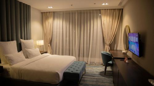 a hotel room with a bed and a television at فندق سدو بوتيك Hotel SDU BOUTIQUE in Jazan
