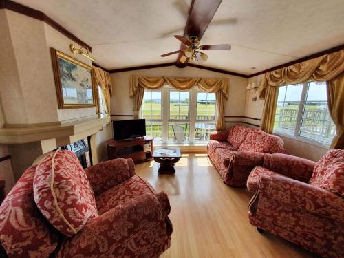 a living room with two couches and a ceiling fan at Hurst View Caravan Park in Lymington