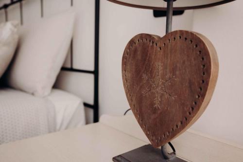 a wooden heart on a table next to a bed at Residence Rose di Fratta in Cupramontana