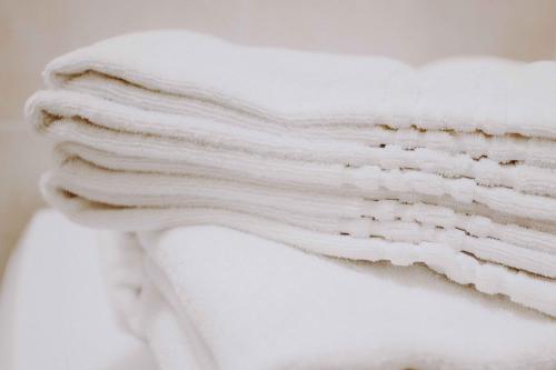 a stack of white towels sitting on top of a toilet at Residence Rose di Fratta in Cupramontana