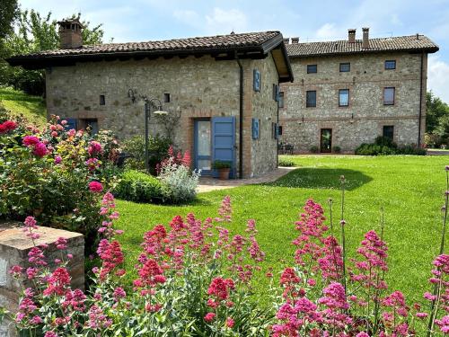 an old stone building with flowers in front of it at Agriturismo Podere Prasiano in Marano sul Panaro