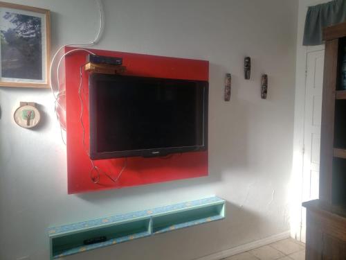 a flat screen tv hanging on a wall at ANNANDA in Florianópolis