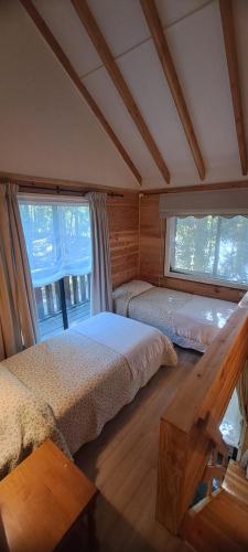a bedroom with two beds and a window at Nidos del Chucao in Pucón