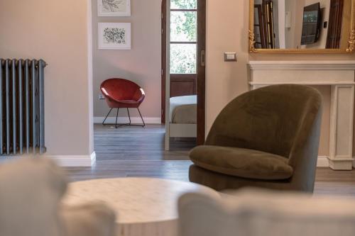 a living room with a chair and a mirror at Villa Il Poggetto - Tuscany living in Massa Marittima