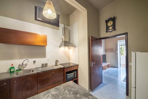 a kitchen with a sink and a clock on the wall at João Loft I by Mth in Campanário