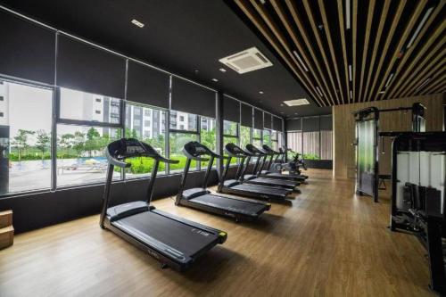 a row of treadmills in a gym with windows at La Dimora Gamuda Cove Splash Mania in Pulau Kempas