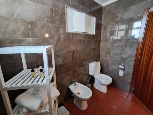 a small bathroom with a toilet and a sink at Haus Am Grünen Meer in Angra do Heroísmo