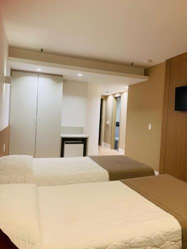 a hotel room with two beds and a desk at South American Copacabana Hotel in Rio de Janeiro