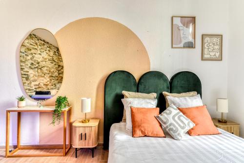 Schlafzimmer mit einem Bett mit einem großen grünen Kopfteil in der Unterkunft Parenthèse Occitane - Free Parking - Balnéothérapie in Carcassonne