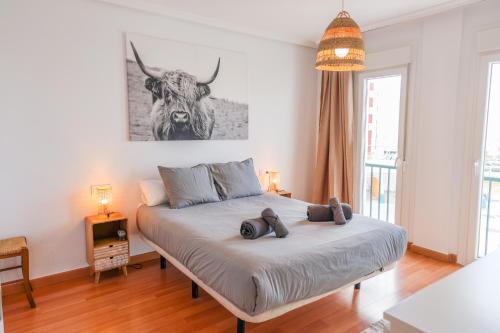 a bedroom with a bed with a bull picture on the wall at Tarifa Cozy House - Casita Central in Tarifa