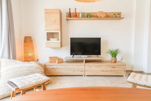 a living room with a flat screen tv on a wooden entertainment center at Tarifa Cozy House - Casita Central in Tarifa