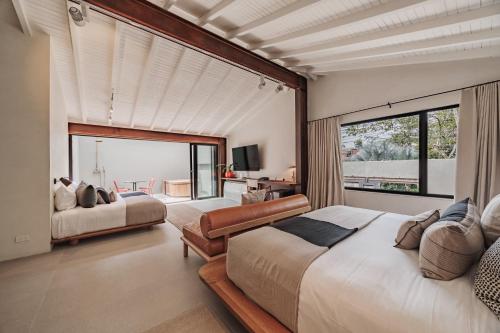 a bedroom with two beds and a large window at EP Casa Uribe Architecture Art & Nature in Medellín