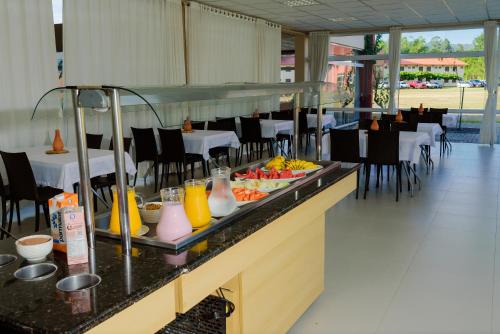 ゴヴェルナドール・セウソ・ラーモスにあるPousada Divino Oleiro - Gov. Celso Ramosのテーブルと椅子のあるレストランでのビュッフェ式朝食