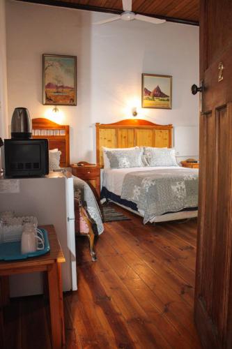 a bedroom with two beds and a television in it at Ebenhaeser guesthouse in Colesberg