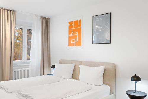 una camera da letto bianca con divano e finestra di Anytime - Ferienwohnungen am Uferpark direkt am See a Friedrichshafen